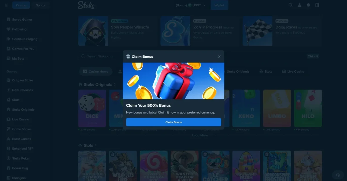 A copy of the Stake casino lobby sits dimmed in dark navy behind a pop-up titled Claim Bonus, where a blue gift box with a red ribbon floats among gold coins on a bright blue background. Under the picture, white text reads Claim Your 500% Bonus above a wide blue Claim Bonus button.